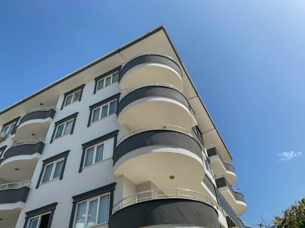 在蓝色天空衬托下的现代美丽的白色建筑中，圆敞的凉亭阳台图片下载