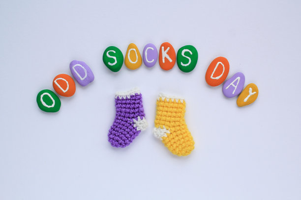 奇怪的袜子日字母和不匹配的彩色袜子在白色背景。社会学校欺凌的概念。丢了寂寞的袜子。图片下载
