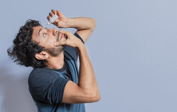 人们用清爽眼药水治疗发炎的眼睛。一名男子在他的眼睛里滴了一个滴管。眼疾患者用滴管滴眼药水，眼疾患者用滴管滴眼药水图片下载