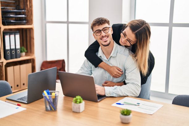 在办公室工作的年轻男女职员相互拥抱图片下载