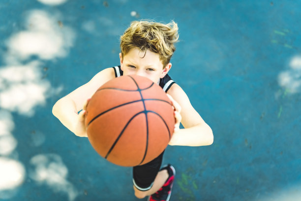 一个男孩在公园里打篮球的画像图片下载