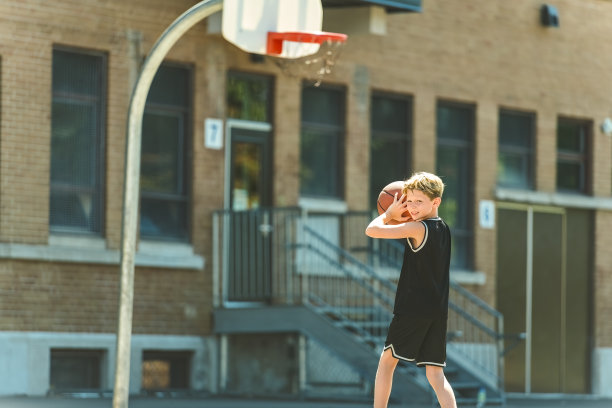 一个男孩在公园里打篮球的画像图片下载