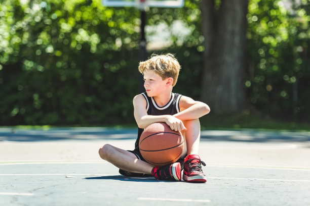 一个男孩在公园里打篮球的画像图片下载