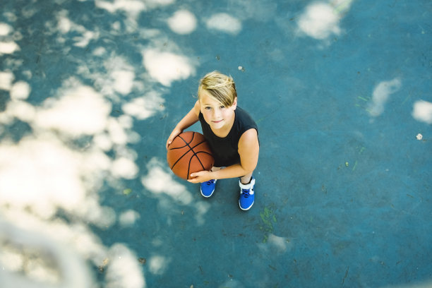 一个男孩在公园里打篮球的画像图片下载