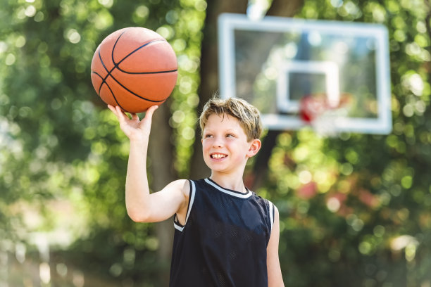 一个男孩在公园里打篮球的画像图片下载