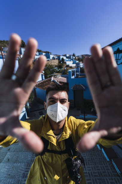 竖版照片：戴着口罩摆姿势的年轻男人——新常态概念图片下载