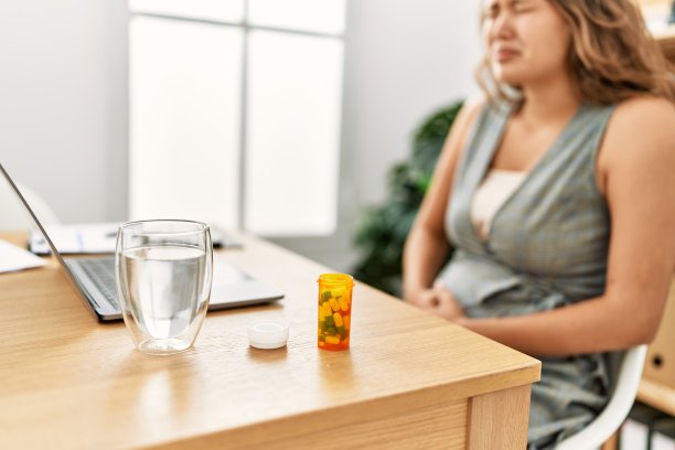 年轻美丽的西班牙女商务工作者在办公室忍受胃痛图片下载