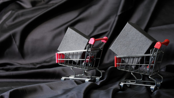 超市里的金属手推车，黑色丝绸背景的黑盒子。黑色星期五的促销概念。副本的空间。图片下载