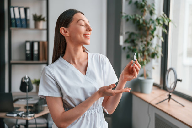 注射药物的注射器。穿着白大褂的年轻漂亮的女医生在办公室图片下载