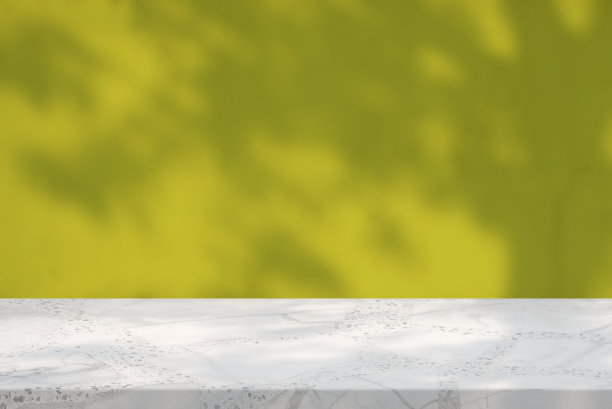 大理石桌子与自然阴影在金色混凝土墙纹理背景，适合化妆品展示背景，展示，和模拟。图片下载