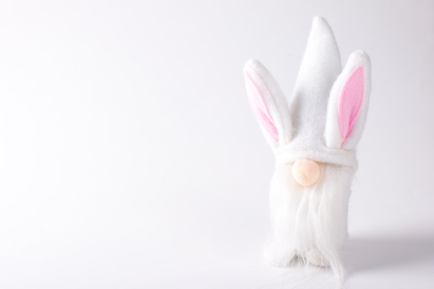 一个穿着白色衣服和粉红色耳朵的斯堪的纳维亚玩具侏儒。在白色背景上复制空白图片下载