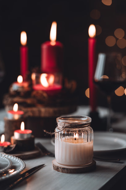圣诞或新年家庭晚餐的乡村餐桌装饰。配红蜡烛，干橙，圆锥形，肉桂，八角。零废物环保家居。舒适的氛围，深色的背景。近距离图片下载
