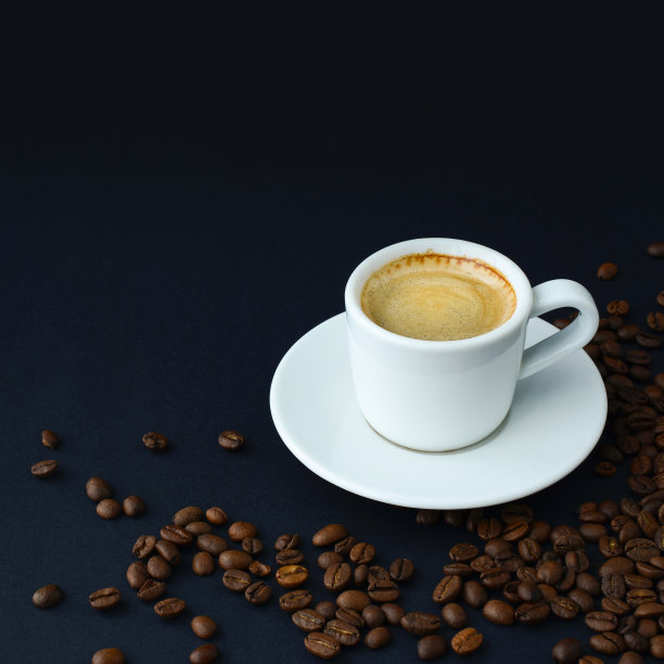 一杯热黑咖啡和烤咖啡豆在桌子上的黑色背景。浓缩咖啡，咖啡卡图片下载