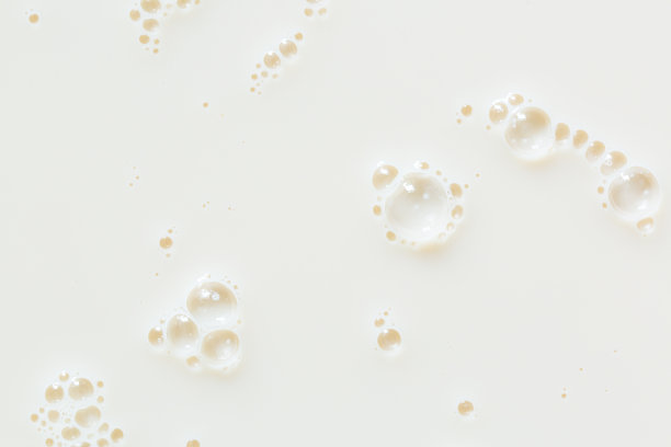 宏观的牛奶质地，白色的牛奶表面和泡沫和波纹从上方鸟瞰图片下载