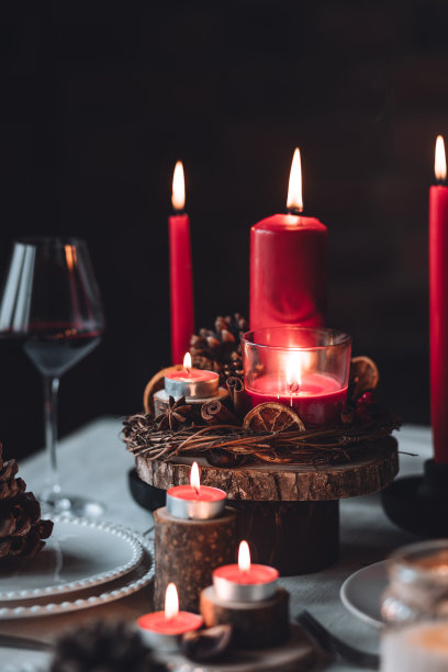 圣诞或新年家庭晚餐的乡村餐桌装饰。配红蜡烛，干橙，圆锥形，肉桂，八角。零废物环保家居。舒适的氛围，深色的背景。近距离图片下载