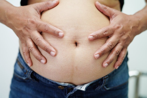 亚洲女性在办公室表现出胖肚子、大身材、超重和肥胖。图片下载