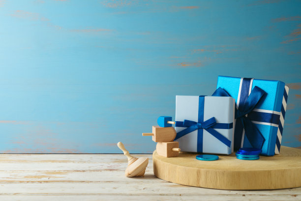 礼品盒和陀螺放在木桌上。光明节节日背景图片下载