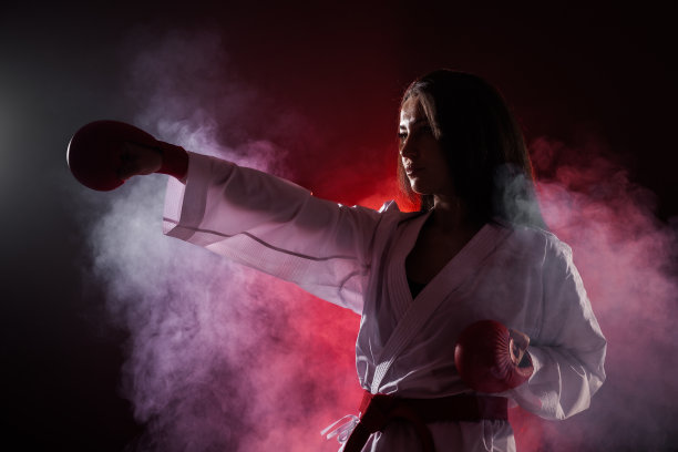 女孩在红色的雾背景下练习空手道拳图片下载