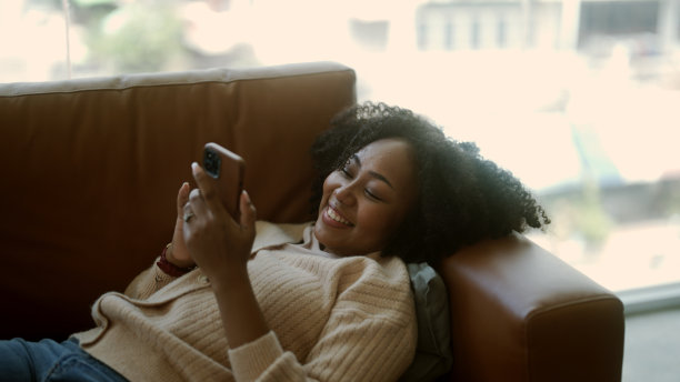 黑人妇女在手机上听笑话大笑图片下载