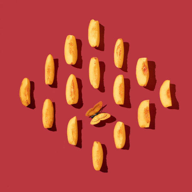 用鲜桃片在深红背景上创作的图案。夏季水果摆放最少。图片下载