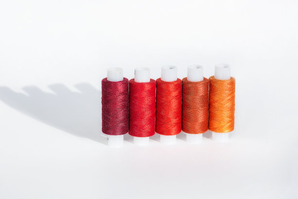 定制工作场所与彩色螺纹线圈。以缝纫为爱好。白色背景俯视图。最小的风格。图片下载