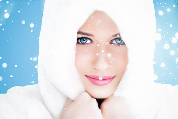 节日快乐，美丽和冬季时尚，美丽的女人穿着白色蓬松的皮大衣，蓝色背景下的雪花作为圣诞、新年和节日的生活方式画像图片下载