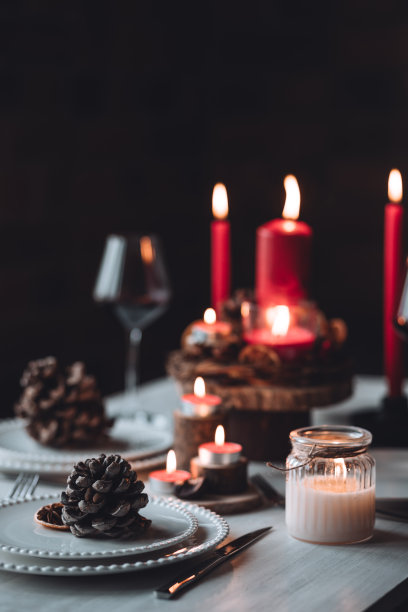 圣诞或新年家庭晚餐的乡村餐桌装饰。配红蜡烛，干橙，圆锥形，肉桂，八角。零废物环保家居。舒适的氛围，深色的背景。近距离图片下载