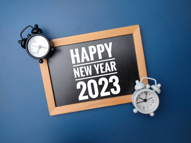 木制框架和闹钟，蓝色背景上写着2023年新年快乐。图片下载