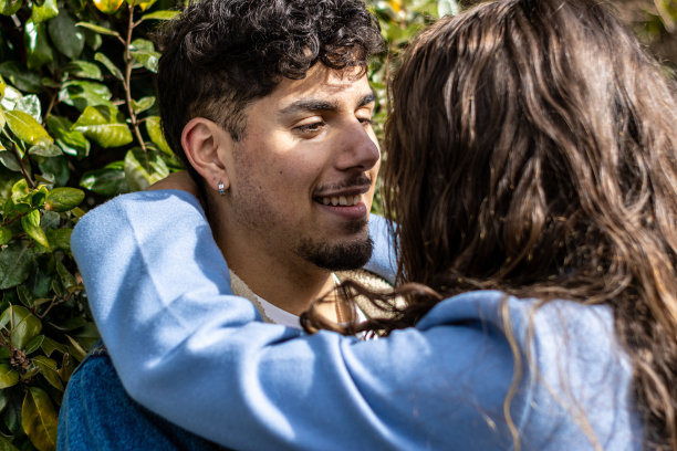 这是一对年轻夫妇站在户外互相拥抱凝视的特写镜头图片下载