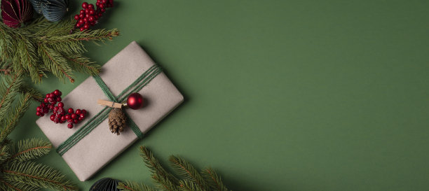 横幅上有圣诞礼物和绿色背景的圣诞树树枝。图片下载