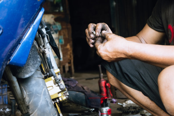技工在车间修理摩托车的特写图片下载