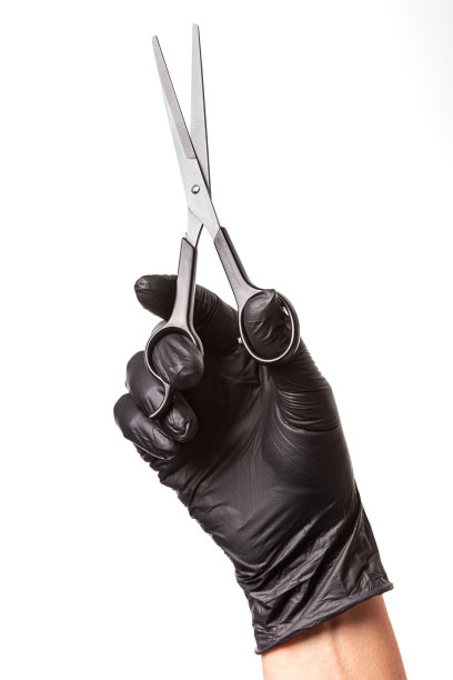 理发师手戴黑色橡胶手套拿着剪刀。白色背景，特写图片下载