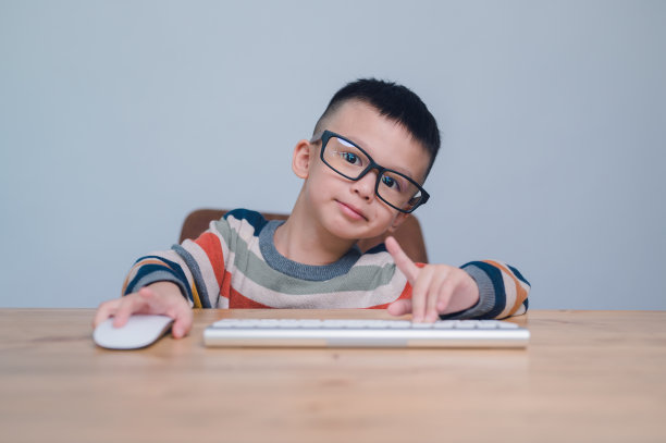 聪明的孩子，可爱的亚洲男孩使用鼠标和电脑键盘，在家上学，在线学习，家庭隔离，在线学习，冠状病毒或教育技术概念，5岁。图片下载