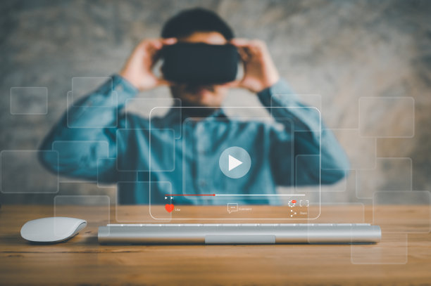 男子戴着VR眼镜，使用鼠标和键盘进行在线流媒体，观看网上视频，现场音乐会，表演或教程图片下载