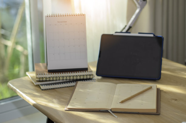 商务高管家庭办公室办公桌背景概念。商务平板空空的家庭办公桌子与桌面日历，电话，笔记本，书，预约议程，灯和铅笔。图片下载