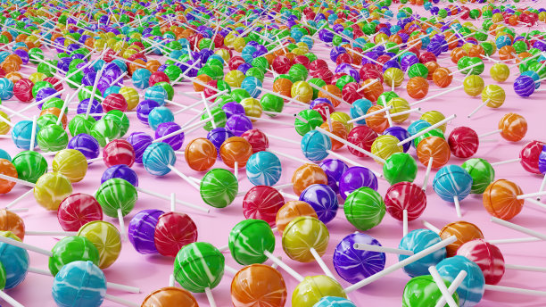 五颜六色的橙、蓝、紫、黄、绿棒棒糖点缀在粉红色的背景上。小快乐的概念，罪恶的快乐和甜食成瘾图片下载