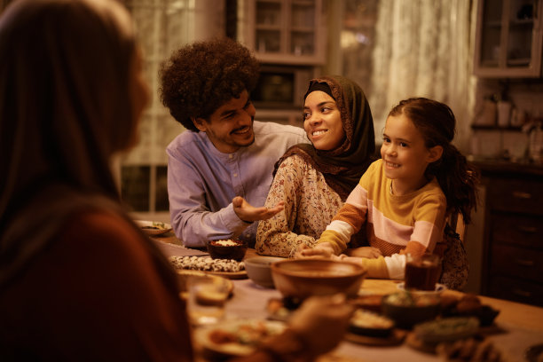 快乐的中东家庭在餐桌上交谈。图片下载