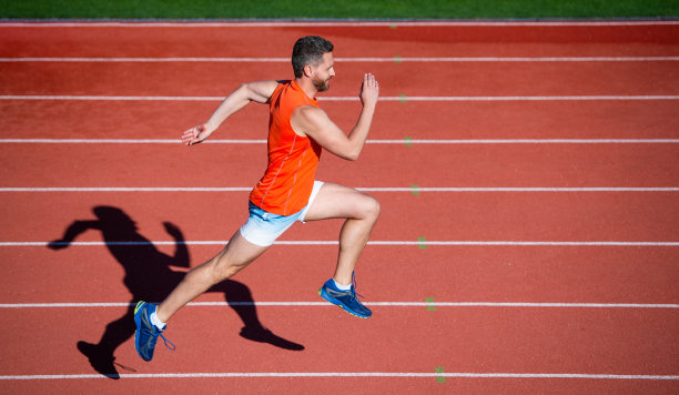 锻炼例程。挑战和竞争。马拉松的速度。运动员跑得快就能赢。成功的健身短跑运动员。男教练在体育场跑道上跑步。耐力和耐力。跑道上的跑步者图片下载