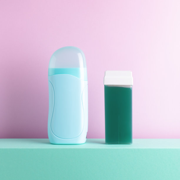 前视图的电蜡加热器脱毛蜂蜜蜡辊在彩色背景。图片下载