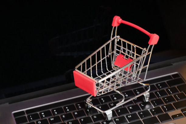 笔记本电脑键盘上的购物车。网上购物，网上商店，电子商务概念图片下载