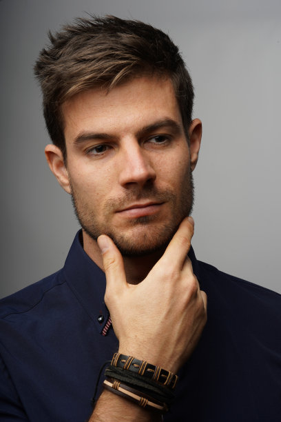 一个年轻的商人在思考时轻轻地托着下巴的垂直镜头图片下载