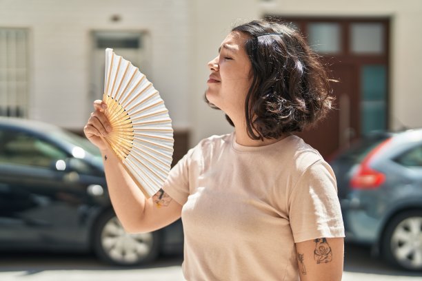 年轻女子在街上用手扇图片下载