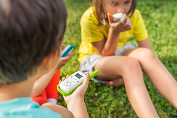 小孩，女孩玩对讲机。带频道的对讲机。侦探，间谍的游戏。孩子们在远处说话，说信息。在森林、公园、远足与家长交流。寻找走失的人图片下载