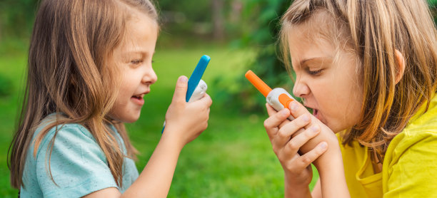 小孩，女孩玩对讲机。带频道的对讲机。侦探，间谍的游戏。孩子们在远处说话，说信息。在森林、公园、远足与家长交流。寻找走失的人图片下载