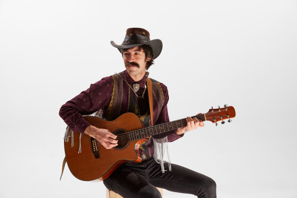 男人的肖像，留着小胡子，穿着乡村风格的衣服，在白色背景上弹奏吉他。灵魂的表达图片下载