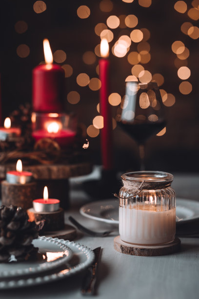 圣诞或新年家庭晚餐的乡村餐桌装饰。配红蜡烛，干橙，圆锥形，肉桂，八角。零废物环保家居。舒适的氛围，深色的背景。近距离图片下载