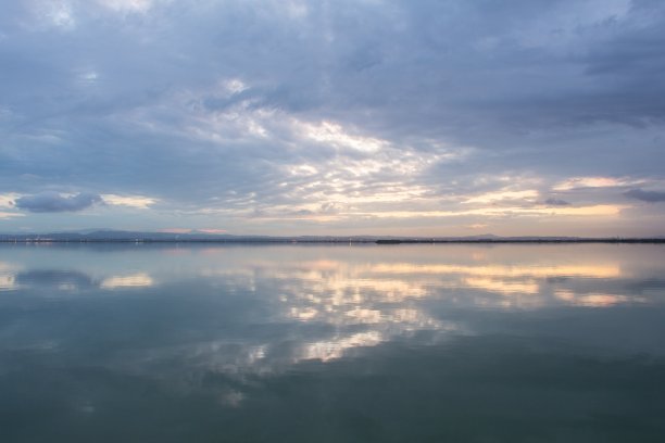 令人窒息的景色的日落天空与暴风雨云反射在水面上图片下载