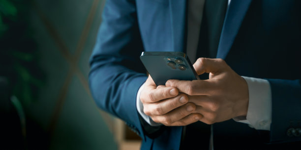 西装革履的商人手里拿着手机。男人打字留言，使用社交网络。检查消息。正在开商务会议。现代办公室。总经理、首席执行官。呼唤合伙人。计划工作日图片下载