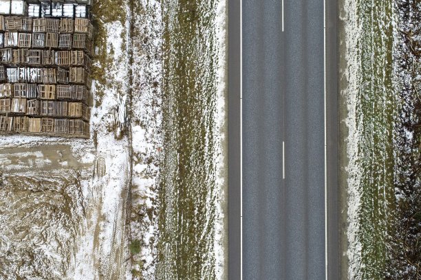 高角视角的道路周围的草地覆盖着雪和金属物体图片下载
