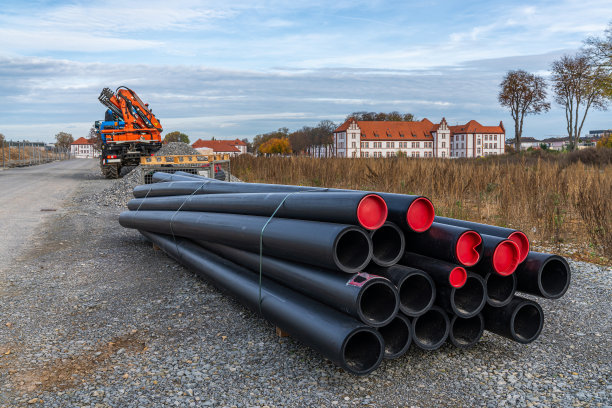 工地上躺着黑色的塑料管子和红色的塞子。图片下载